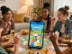 Eager group enjoying Card Rummy, showcasing download file on mobile device in a cozy living room setting.