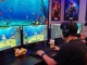 Engaging gamer playing 78WIN fishing game with vibrant underwater visuals and multiple screens.